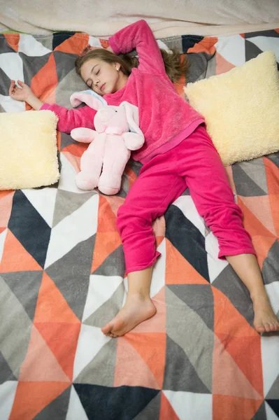 Small girl child ready to sleep. Time to relax. Childhood happiness. Pajama party. Good night. Little happy girl in bedroom. Good morning. International childrens day. What an interesting toy — Stock Photo, Image