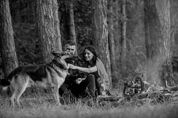 Alman çoban köpeği olan çift şenlik ateşinin yanında, doğa geçmişi var.. — Stok fotoğraf
