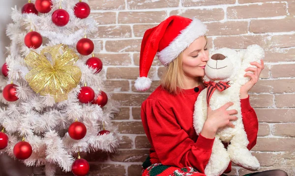 Chica feliz celebrar la Navidad de año nuevo. Recibe osito de peluche como regalo. Te deseo feliz navidad. Los mejores regalos para la familia. Lindo y tierno regalo. Mujer santa sombrero abrazo suave oso de juguete. El mejor regalo de todos — Foto de Stock