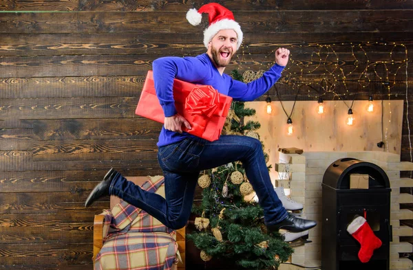 Man santa hat hurry to deliver gift on time. Spread happiness and joy. Bearded guy in motion jump. Delivery christmas present. Gifts delivery. Still have time. Delivery service. Christmas is coming