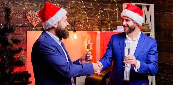 Corporate partij New year. Mensen uit het bedrijfsleven drinken champagne op feestje. Partij met champagne. Collega's vieren Nieuwjaar. Mannen formele pakken en santa hoeden houden champagneglazen. Cheers concept — Stockfoto