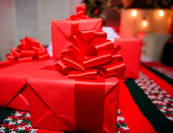 Piros keresztkötés ajándék, vagy jelent. Készítsünk karácsonyi és újévi. Csomagolás, ajándék fogalmát. Varázslatos pillanatokat. Készítsük el a család és a barátok meglepetés ajándékok. Ajándék dobozok nagy szalag íj közelről — Stock Fotó