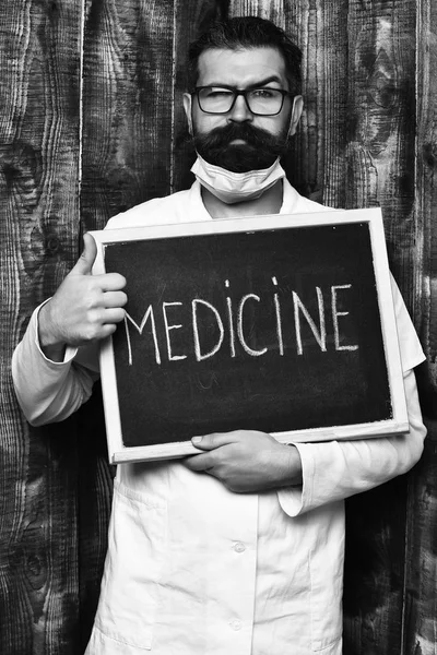 Barbu brutal caucasien médecin holding conseil avec médecine inscription — Photo