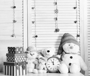 Kardan adamlar, oyuncak ayılar ve çalar saatin yanındaki kutular.