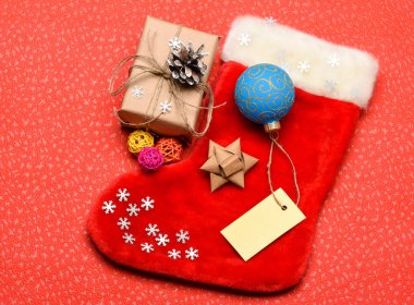 Noel çorap çorap çanta şeklinde. Aile gelenekleri tutun. Çorap stuffers fikir. Noel Baba Noel hediye kutusu ile çorap. Noel çorap kırmızı arka plan üstten görünüm. Geleneksel Noel özniteliği