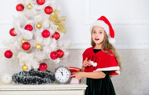 Girl kid santa hat costume with clock counting time to new year. How much time before. Last minute till midnight. New year countdown. Last minute new years eve plans that are actually lot of fun — Stock Photo, Image