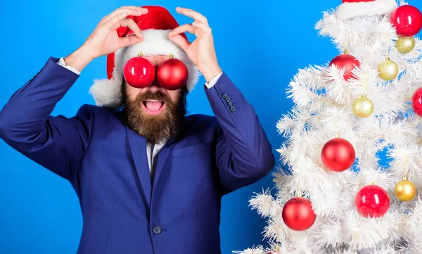 Concepto de negocios y navidad. Santa celebrar la decoración de la bola de Navidad. Vacaciones para divertirse. Empresario unirse a la preparación de Navidad. Diversión de Navidad. Hombre barbudo hipster llevar traje formal y sombrero de santa —  Fotos de Stock