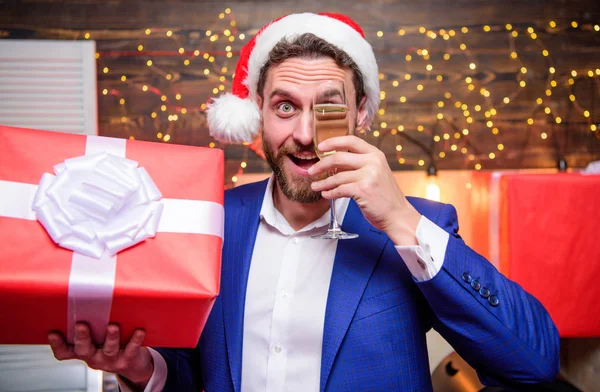 New year party. Cheers. Man bearded businessman celebrate new year with glass of champagne and gift box. Happy new year and merry christmas. Cheerful manager formal suit celebrate corporate party