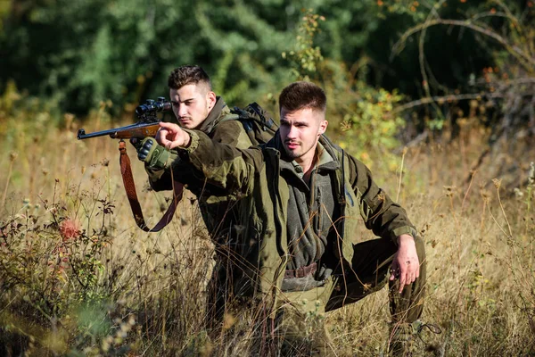 Avcılar doğa ortamında tüfeklerle. Avcı arkadaş alanında eğlence keyfini çıkarın. Avcılar gamekeepers hayvan veya kuş arıyorsunuz. Arkadaşlar hobi eğlence ile avcılık. Gerçek erkekler kavramı için hobi — Stok fotoğraf