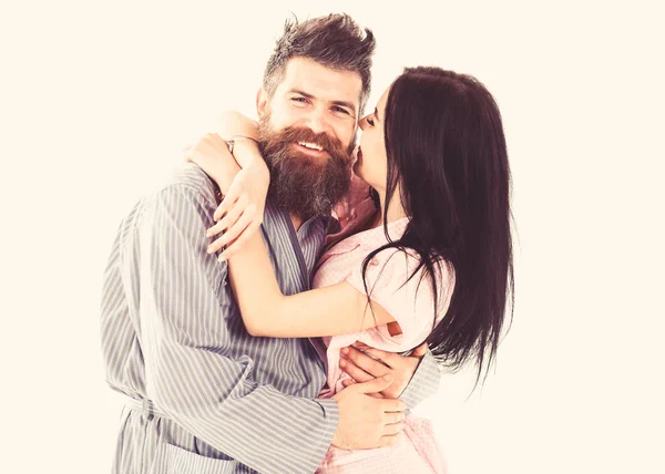 Couple in love hugging in pajama, bathrobe. Couple cuddling, girl kissing macho, isolated on white background. Couple, family on smiling faces happy in morning. Relations goals concept