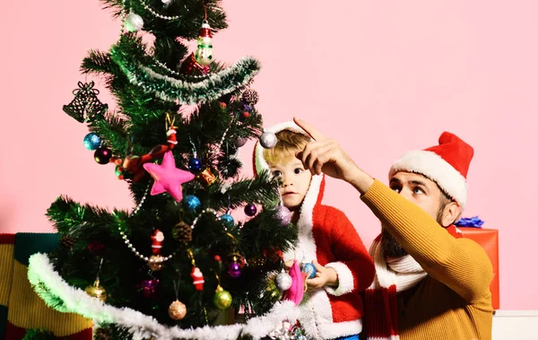 Babbo Natale e il piccolo figlio stanno vicino all'albero di Natale. — Foto Stock