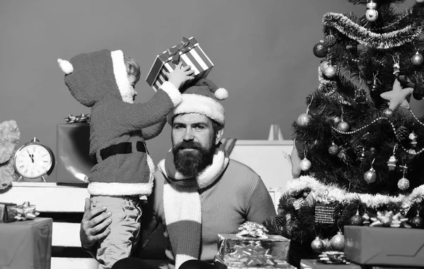 Weihnachtsfamilie öffnet Geschenke auf rotem Hintergrund. — Stockfoto