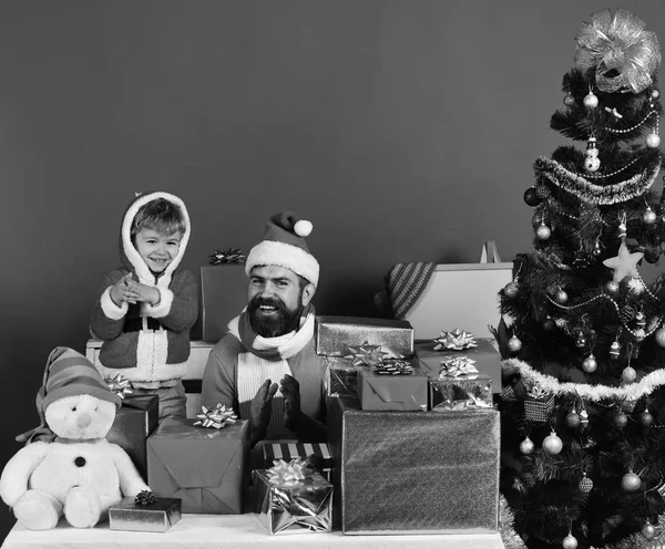 Boże Narodzenie rodzina otwiera prezenty na czerwonym tle — Zdjęcie stockowe