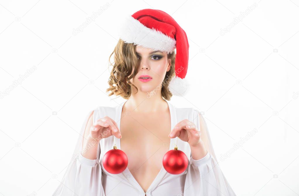 Plastic surgery. Girl santa hat hold balls decorative ornament in front of breasts. Christmas balls symbol implant female breasts. Christmas miracle concept. Breasts augmentation as gift for new year