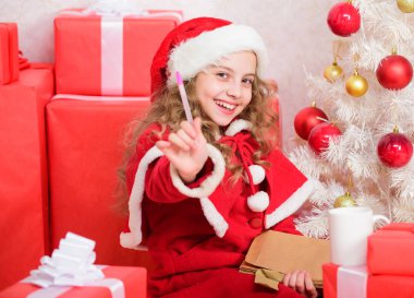 Çocuk Noel Baba'ya mektup yazar. Çocuk Noel Baba kostüm mucizesi inanıyorum. Mektubu Noel Baba için. Dilek listesi. Yıl boyu iyi kızdı. Kız küçük çocuk tutun kalem ve Kağıt Noel ağacı yazılı mektup yakınındaki