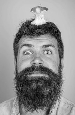 Hipster mutlu yüz baş mavi arka plan, elma güdük hedef ile kapatın. Adam yakışıklı hipster uzun sakal neredeyse kafasına elma güdük hedef olarak yem. Kilo kaybı gol. Canlı hedef kavramı