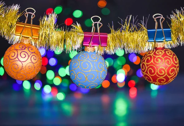 Lametta mit angeheftetem Weihnachtsschmuck auf defokussiertem Lichterkranz Hintergrund. Weihnachtsschmuck-Konzept. Kugeln mit Ornamenten hängen an schimmerndem Lametta. Wählen Sie bunte Dekor für Weihnachtsbaum — Stockfoto