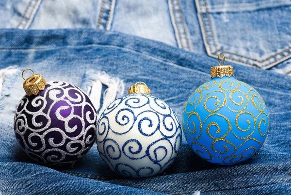 Três bolas de Natal decoração calças jeans fundo. Conceito de férias de inverno. Decore a árvore de Natal com brinquedos tradicionais. Símbolo de feriados de ano novo e Natal. Celebre o Natal — Fotografia de Stock