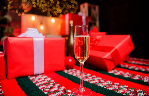 Nieuwjaar traditionele kenmerk. Gelukkig nieuw jaar en merry christmas. Glas champagne close-up. Champagne elegante glazen. Glas gevuld mousserende wijn of champagne in de buurt van geschenkdozen. Nieuwjaar vieren — Stockfoto