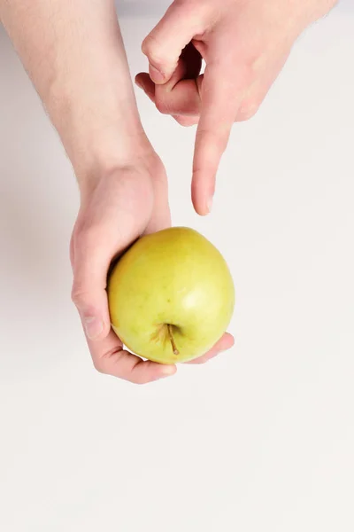 Vitaminas y concepto de fitness. Puntos de mano masculinos en manzana verde — Foto de Stock