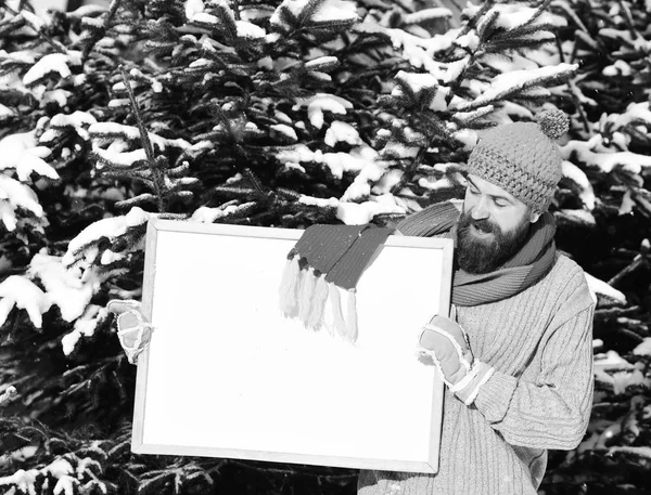 Man wears knitted hat, scarf and gloves with smiling face.