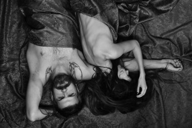 Sakallı ve endişeli yüzlü adam bir bayanla yatıyor.