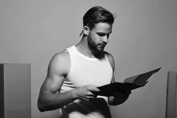 stock image Deliveryman with concentrated face holds folder. Guy with muscular hands