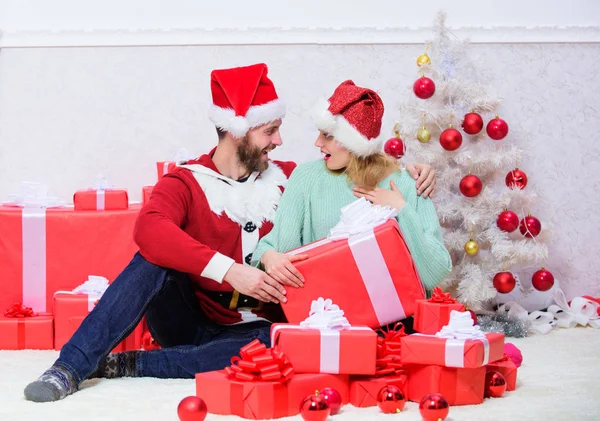 Loving couple unpacking gift christmas tree background. Couple in love happy enjoy christmas holiday celebration. Husband prepared christmas surprise. Opening christmas present. What a surprise