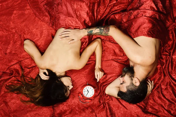 Casal apaixonado em lençóis vermelhos. Sexo e manhã perfeita — Fotografia de Stock