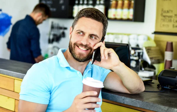 コーヒー ブレークのコンセプトです。コーヒーは、忙しい人のためのオプションを奪います。男モバイルで会話カフェ バリスタ背景。待っている間にコーヒーを飲みます。あなたを待っています。男のスマート フォン注文カフェでコーヒー — ストック写真