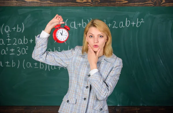 Le importa la disciplina. La profesora sostiene el despertador. Profesora de la escuela. ¿Qué hora es? Horario de clases. Bienvenido año escolar maestro. Salud y régimen diario. Educador lección de inicio — Foto de Stock