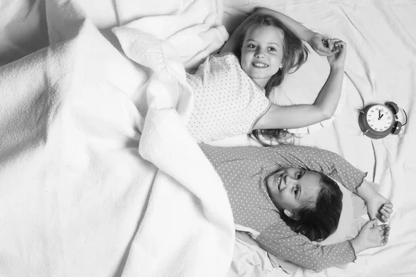 Дети с улыбающимися лицами лежат на розовом и белом фоне — стоковое фото