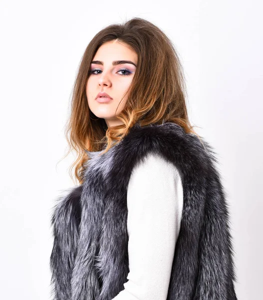 Woman makeup face wear fur vest white background. Luxury fur accessory clothes. Fashion trend concept. Winter fashionable wardrobe for female. Silver fur vest fashion clothing. Boutiques selling fur