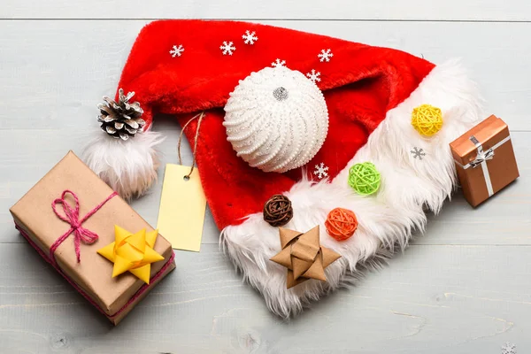 Regalos de Navidad de Santa. Santa sombrero blanco vista superior de fondo. La atmósfera se trata de detalles. Atributos de vacaciones de invierno. Año nuevo y decoraciones navideñas. Sombrero de Santa y caja de regalo de Navidad — Foto de Stock