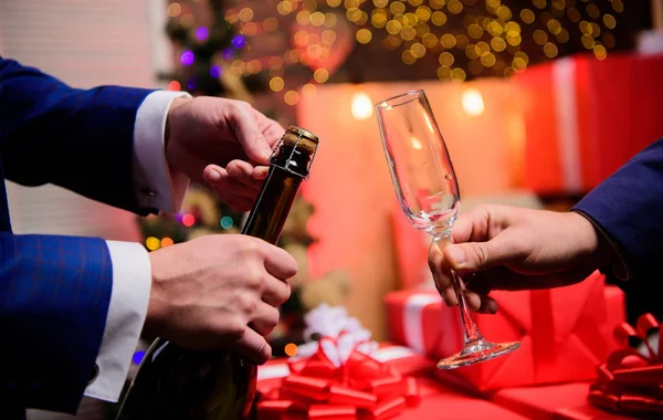 Beba champanhe ou vinho espumante. Celebre o Ano Novo com o champanhe. Último minuto antes do ano novo. Contagem regressiva de ano novo. Mãos abrindo garrafa de champanhe e segure vidro decorações de Natal fundo — Fotografia de Stock