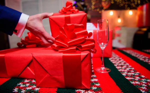 クリスマスと新年に備えます。ラッピング ギフトのコンセプトです。魔法の瞬間。家族や友人のための驚きの贈り物を準備します。大きなリボンの弓でギフト ボックスをクローズ アップ。赤の贈り物をラップやプレゼント — ストック写真