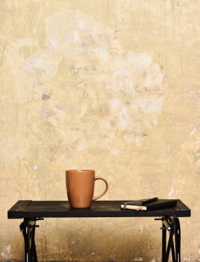 kahverengi çay ya da kahve ya da içki defterini için seramik kupa ışığı ve bej dokulu arka plan üzerinde siyah tepsi pen, girintili kopyalama