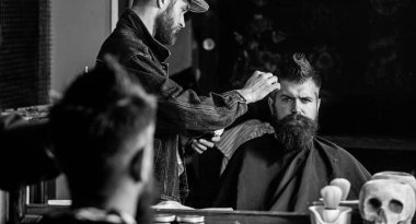 Hipster istemci Başlarken saç kesimi. Kuaför saç kesme makinesi ile saç modeli sakallı, berber arka plan için çalışır. Saç kesimi kavramı. Kuaför styling saç kesme makinesi ile acımasız sakallı istemci