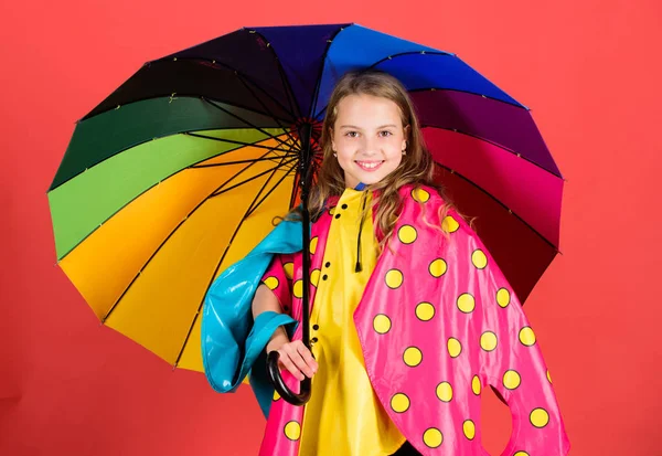 Šťastné dítě dívka drží Barevný deštník opotřebení Nepromokavý plášť. Užijte si deštivé počasí vlastního oblečení. Vodotěsné příslušenství vyrábět. Vodotěsné příslušenství aby deštivý den, veselá a příjemná — Stock fotografie