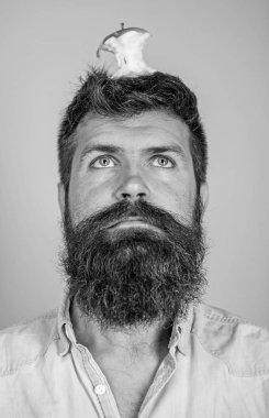 Adam yakışıklı hipster uzun sakal neredeyse kafasına elma güdük hedef olarak yem. Hipster sürpriz elma güdük hedef üzerinde kafa mavi arka plan, yüz kadar yakın. Kilo kaybı gol. Canlı hedef kavramı