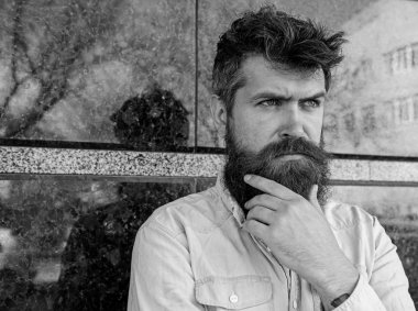 Erkeklik kavramı. Tousled saçlı hippi sakal mesafe içine bakarken dokunur. Adam şüpheli görünüyor. Sakal ve bıyık düşünceli, dalgın yüzünde siyah mermer zemin üzerine olan adam