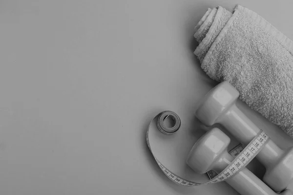 Dumbbells in green color, twisted measure tape and towel — Stock Photo, Image