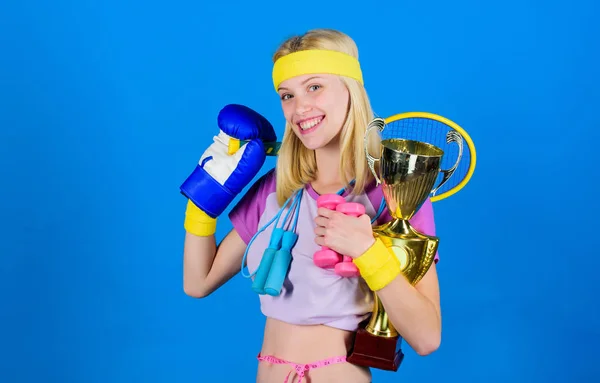 Sport shop assortment. Girl successful modern woman hold golden goblet of sport champion and equipment blue background. How to find time for everything. Sport equipment store. Sport for every day — Stock Photo, Image