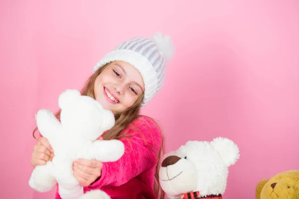 Why kids love stuffed animals. Toy every child dreaming. Kid little girl play with soft toy teddy bear on pink background. Happy childhood concept. Child small girl playful hold teddy bear plush toy