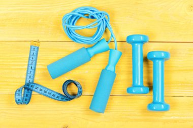 Egzersiz ve aktif yaşam tarzı kavramı. Spor malzemeleri sarı zemin üzerine