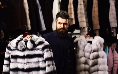 Adam düşünceli yüz kürk moda mağaza içinde gösterir..