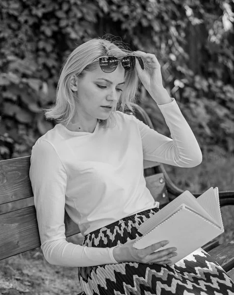 Girl sit bench relaxing with book, green nature background. Reading literature as hobby. Girl keen on book keep reading. Woman blonde take break relaxing in park reading book. Ultimate best book list