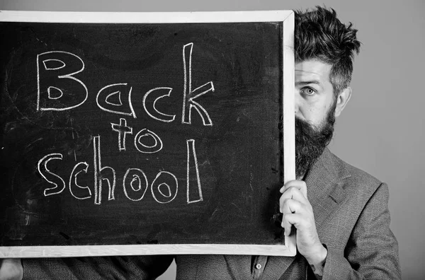 Bent u klaar studie. Leraar of school principal verwelkomt terug naar school. Leraar verstopt achter het schoolbord. Begin schooljaar voor te bereiden. Leraar gluren uit schoolbord op rode achtergrond — Stockfoto