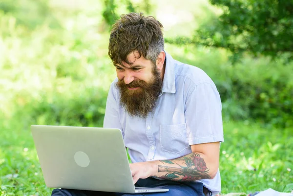 Blogcu doğadan ilham alıyor. Laptoplu sakallı bir adam çayır doğasında oturuyor. İlham veren doğa ortamı arayan bir yazar. Blog yazma ilhamı. İlham arıyorum. — Stok fotoğraf