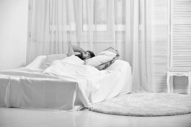 Alin, arka plan üzerinde beyaz perde dokunmadan yatağa, döşeme adam. Baş ağrısı kavramı. Adam acı yüzü sabah uyanma. Baş ağrısı, sabah kalıntı maço sakal ve bıyık ile muzdarip